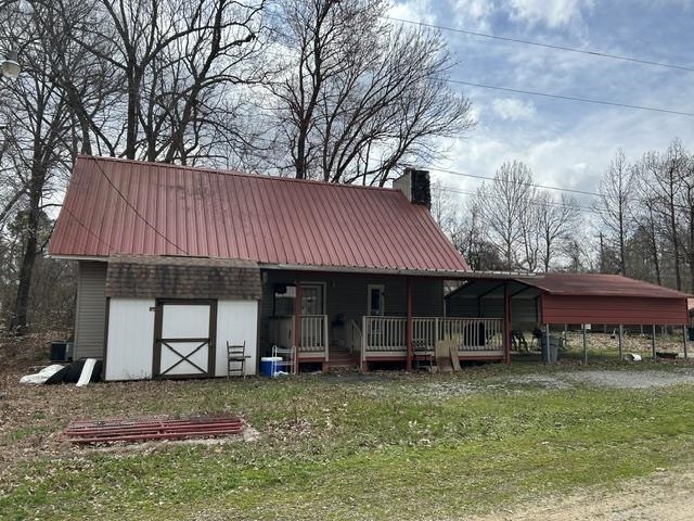 200 Ray Bluff Road Millington, TN 38053 - Photo 1 of 1 Red metal roof, exterior chimney, covered front porch, detached shed, and an additional covered structure