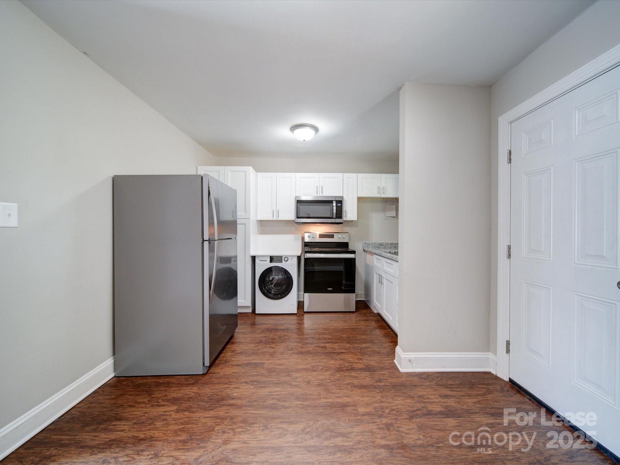 321 South Gardner Avenue, Unit 6 Charlotte, NC 28208 - Photo 12 of 35 a kitchen with a refrigerator a stove top oven and white walls