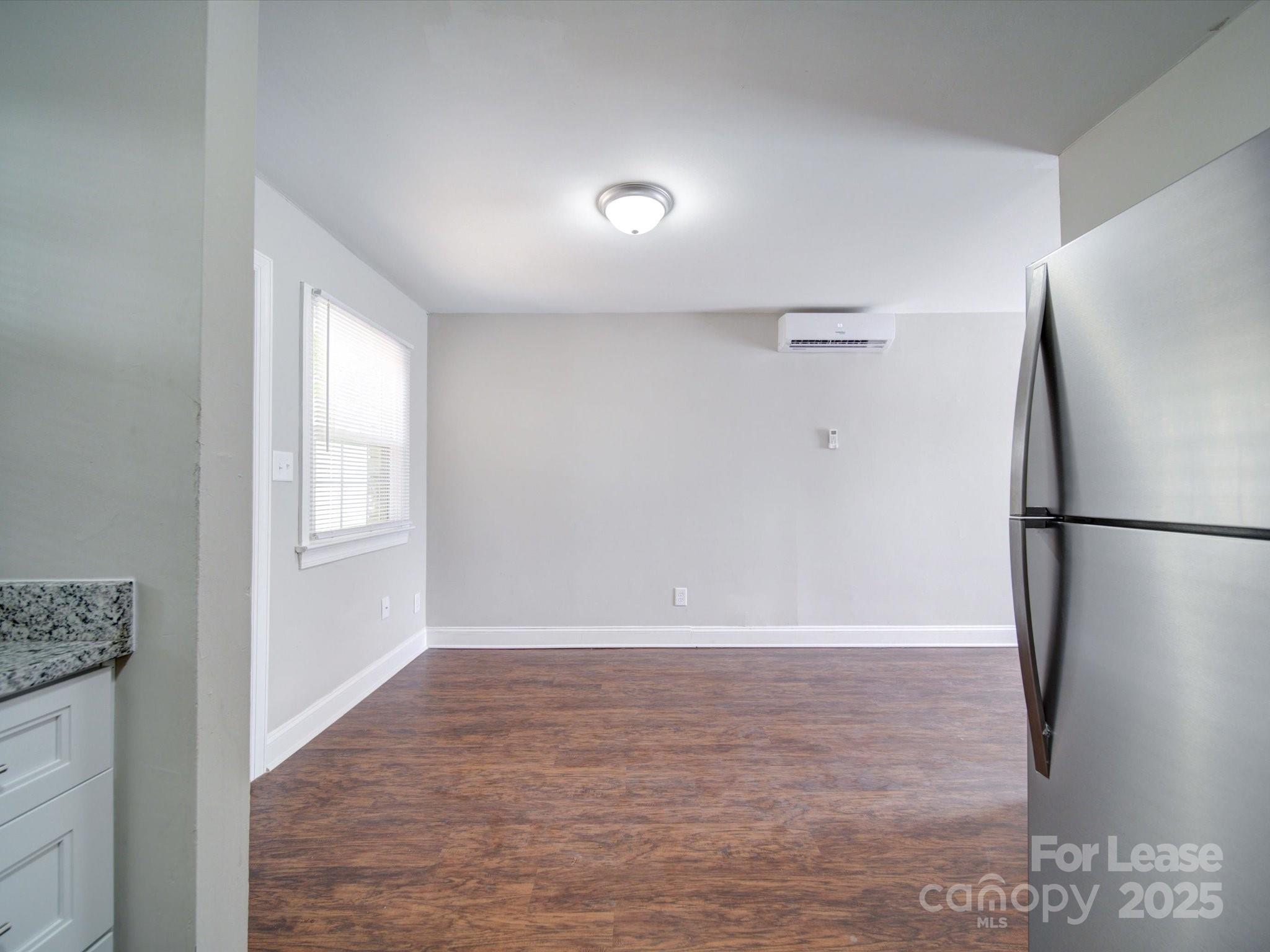 321 South Gardner Avenue, Unit 6 Charlotte, NC 28208 - Photo 18 of 35 a view of an empty room with wooden floor and a window