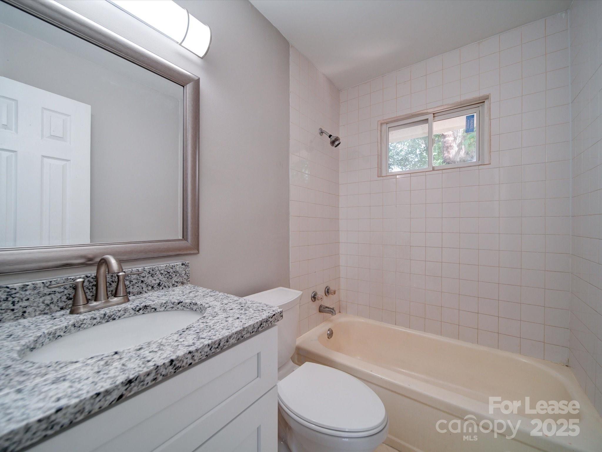 321 South Gardner Avenue, Unit 6 Charlotte, NC 28208 - Photo 27 of 35 a bathroom with a granite countertop sink a toilet and bathtub