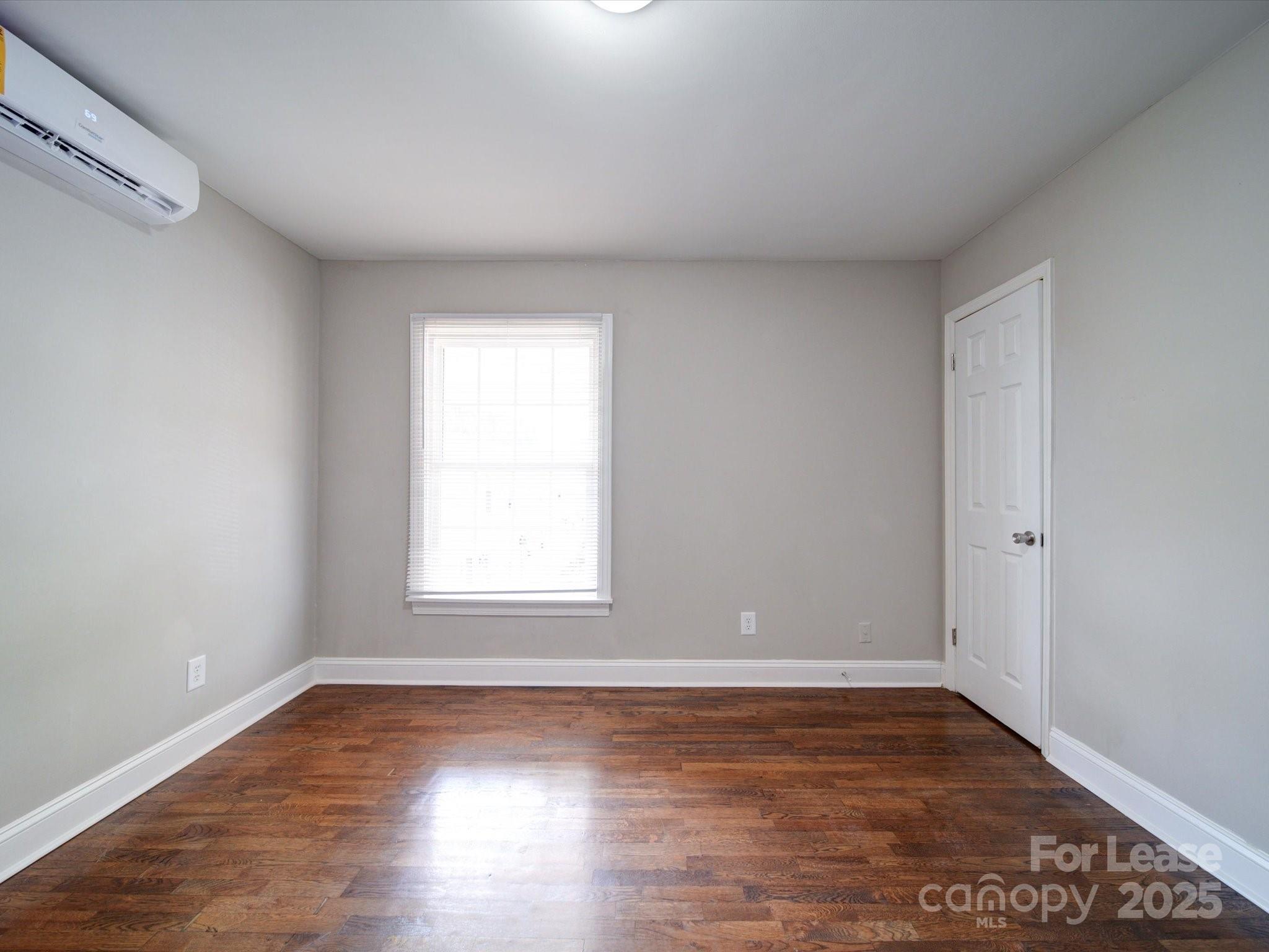 321 South Gardner Avenue, Unit 6 Charlotte, NC 28208 - Photo 31 of 35 a view of an empty room with wooden floor and a window