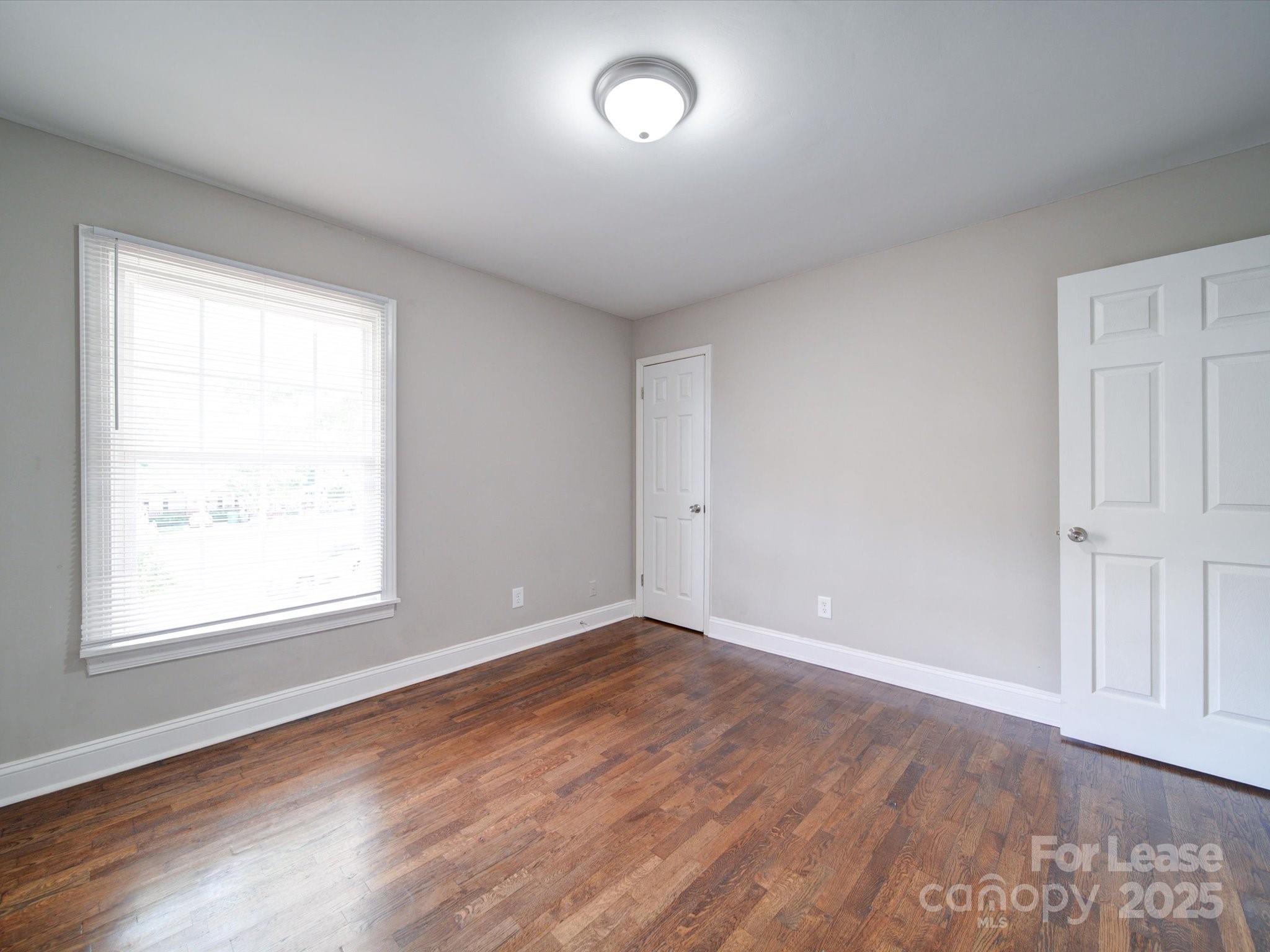 321 South Gardner Avenue, Unit 6 Charlotte, NC 28208 - Photo 32 of 35 an empty room with wooden floor and windows