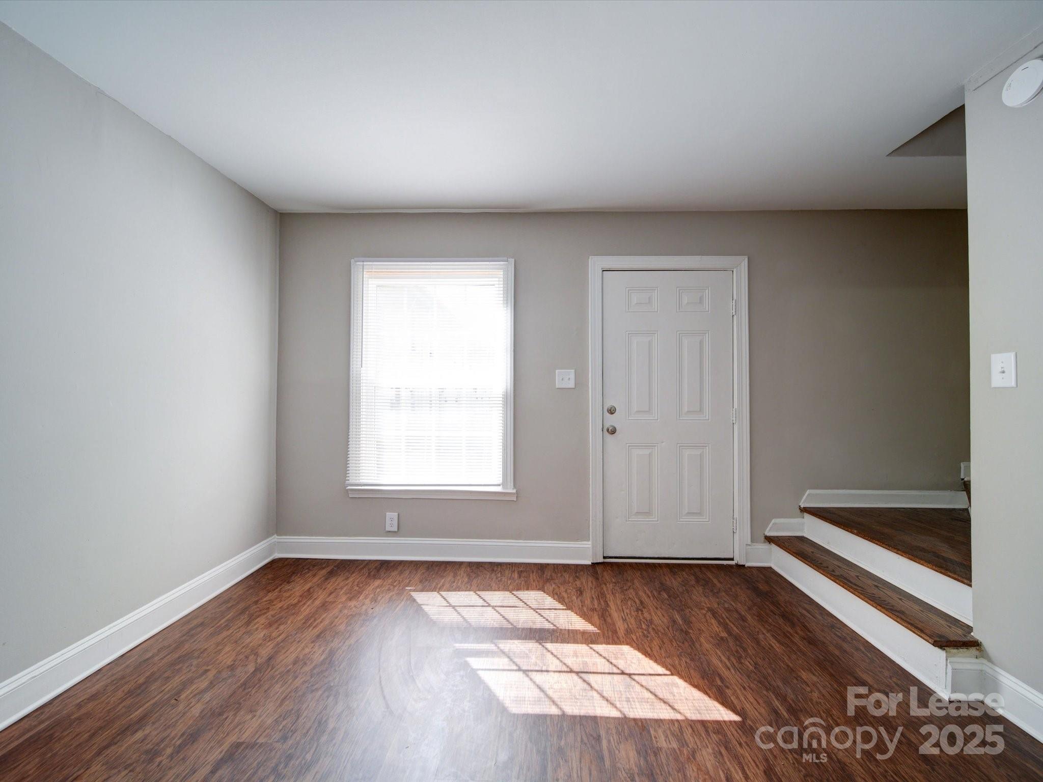 321 South Gardner Avenue, Unit 6 Charlotte, NC 28208 - Photo 8 of 35 an empty room with wooden floor and windows