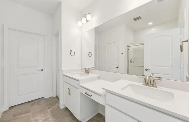 a spacious bathroom with a double vanity sink and a mirror