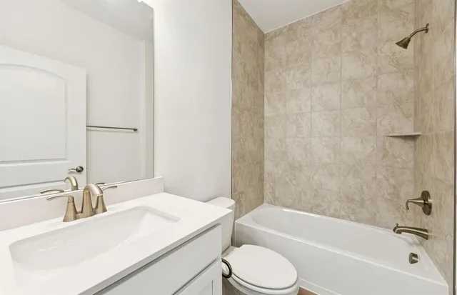 a bathroom with a granite countertop sink mirror toilet and bathtub