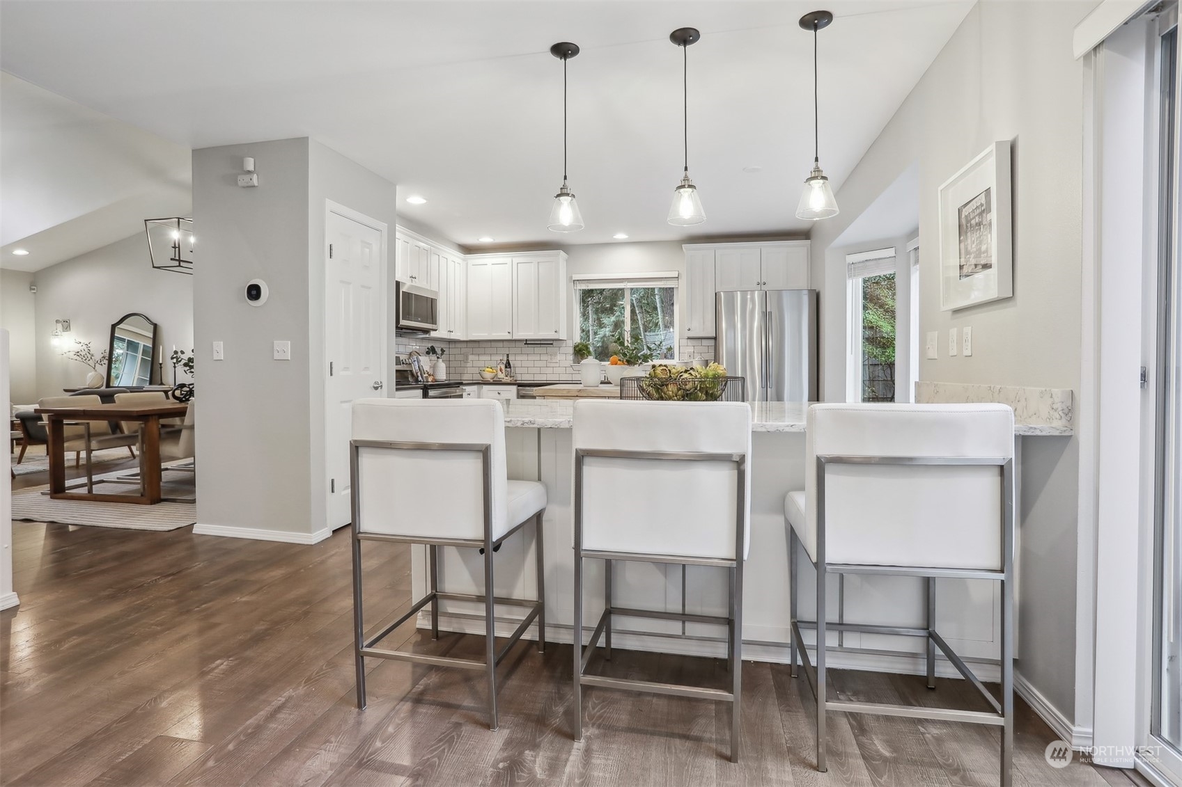 105 170th Street Southeast Bothell, WA 98012 - Photo 7 of 33 a kitchen with stainless steel appliances kitchen island granite countertop a dining table chairs and white cabinets