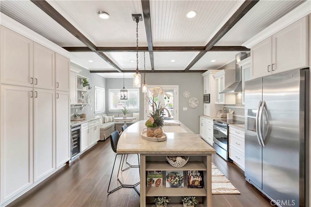621 8th Street Huntington Beach, CA 92648 - Photo 11 of 58 a kitchen with stainless steel appliances granite countertop a kitchen island a stove a table and chairs in it