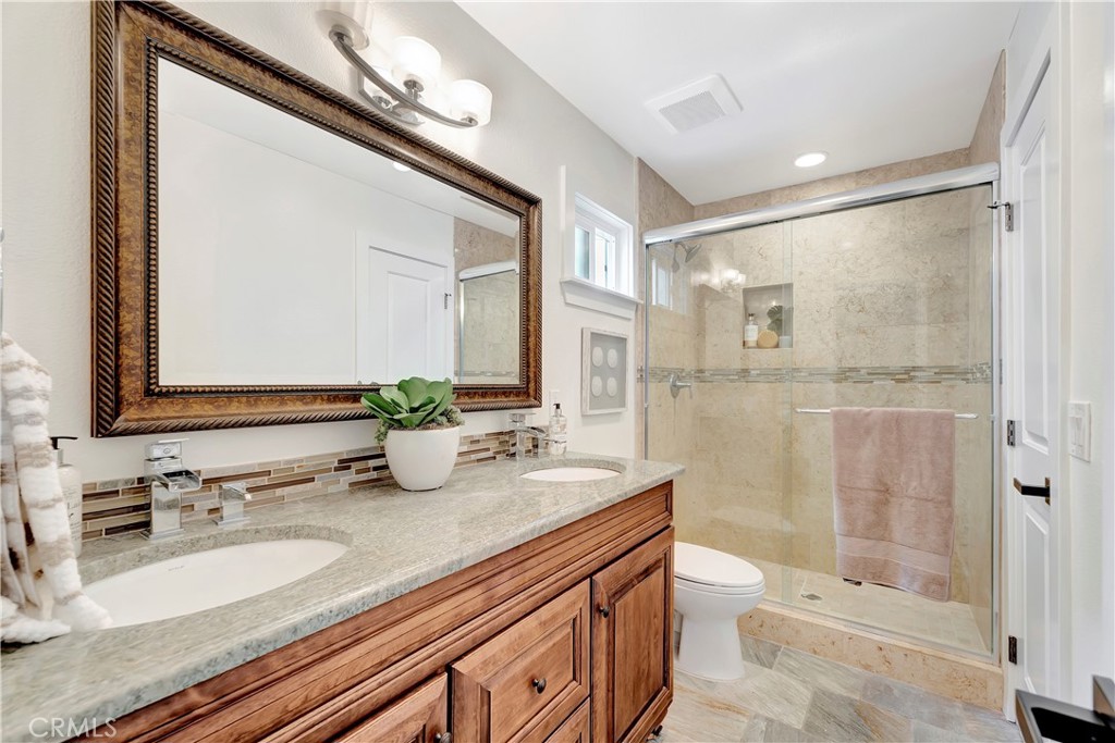 621 8th Street Huntington Beach, CA 92648 - Photo 38 of 58 a bathroom with a granite countertop sink a toilet a mirror and shower