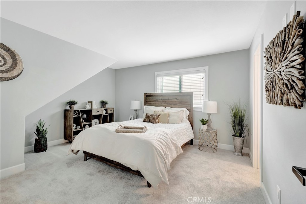 621 8th Street Huntington Beach, CA 92648 - Photo 39 of 58 a bedroom with a bed and a potted plant on the dresser