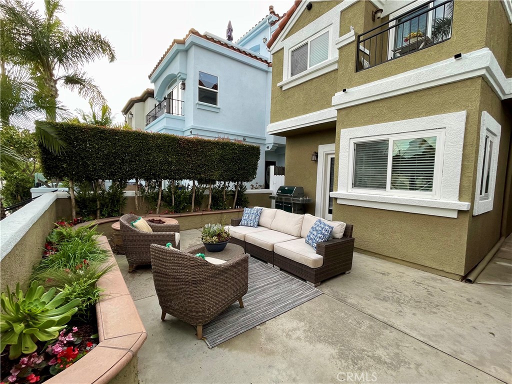 621 8th Street Huntington Beach, CA 92648 - Photo 53 of 58 a view of a patio with couches table and chairs under an umbrella