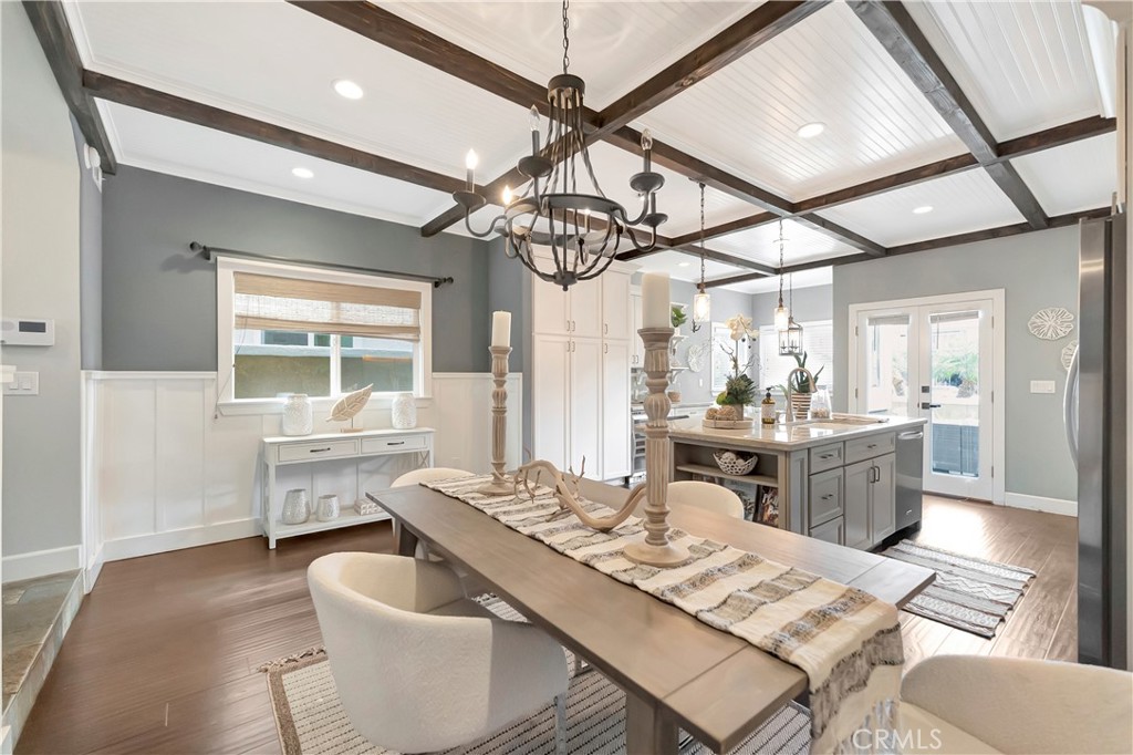 621 8th Street Huntington Beach, CA 92648 - Photo 7 of 58 a dining room with wooden floor a chandelier a wooden table and chairs