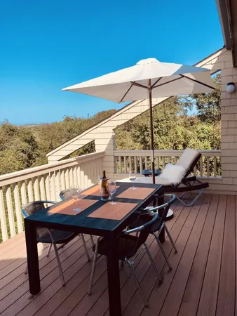 a balcony with wooden floor table and chairs