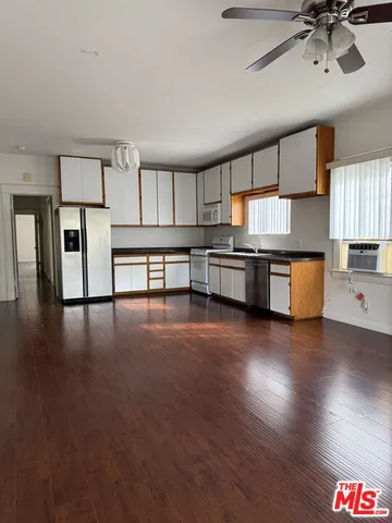 a kitchen with stainless steel appliances granite countertop a sink cabinets and wooden floor