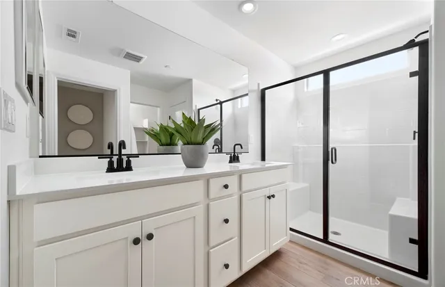 a bathroom with a double vanity sink mirror and shower