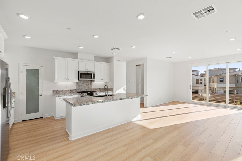234 Siena Lake Forest, CA 92630 - Photo 1 of 22 a large white kitchen with stainless steel appliances kitchen island granite countertop a large stove a sink and a refrigerator