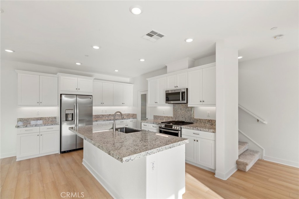 234 Siena Lake Forest, CA 92630 - Photo 6 of 22 a kitchen with kitchen island a counter top space cabinets and stainless steel appliances