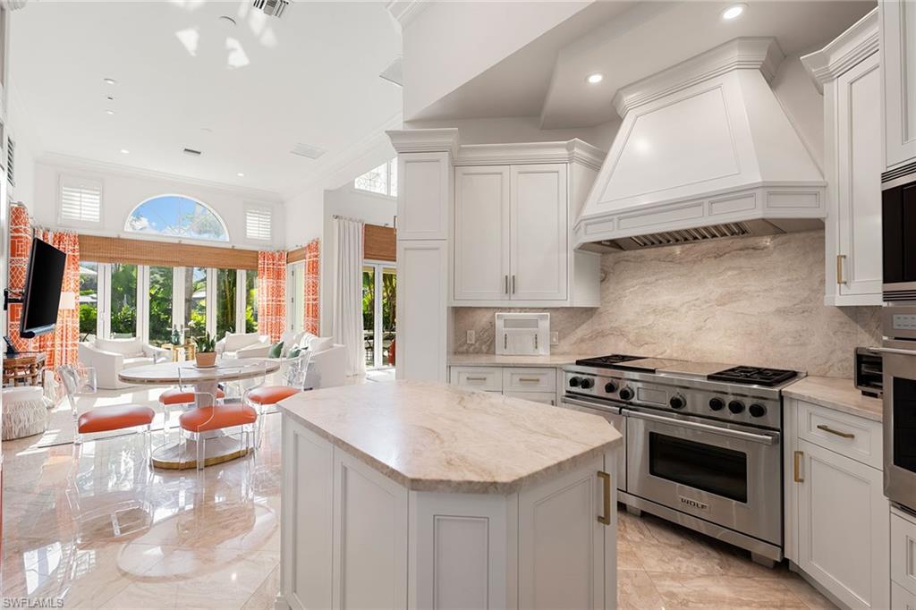248 Point Salerno Naples, FL 34108 - Photo 14 of 42 a large kitchen with granite countertop a stove and white cabinets