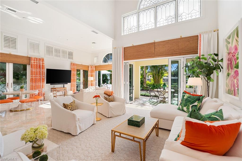 248 Point Salerno Naples, FL 34108 - Photo 2 of 42 a living room with furniture a flat screen tv and a large window