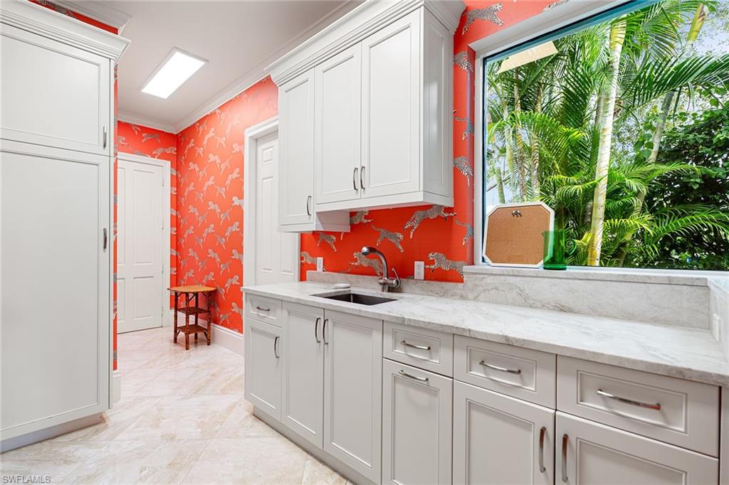 248 Point Salerno Naples, FL 34108 - Photo 36 of 42 a kitchen with wooden cabinets a sink and a window