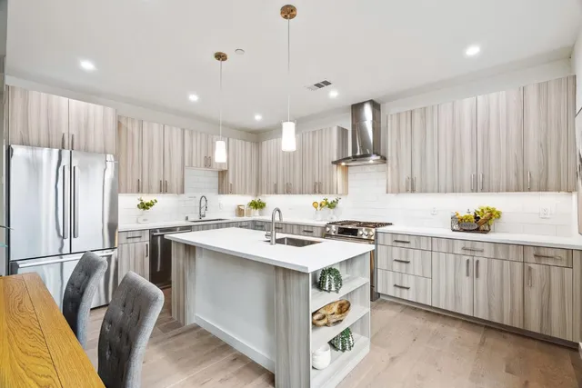 a kitchen with stainless steel appliances granite countertop a sink stove and refrigerator