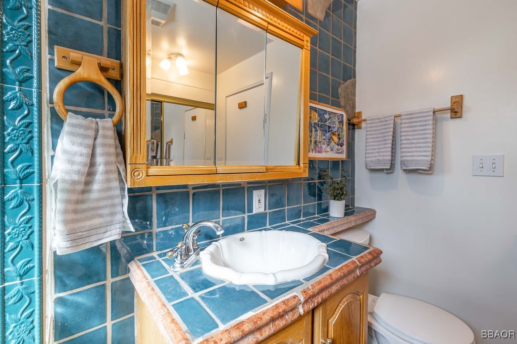 684 Chipmunk Lane Big Bear Lake, CA 92315 - Photo 15 of 49 a bathroom with a toilet a sink and mirror