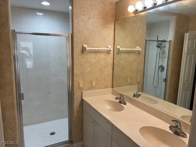 a bathroom with a shower sink and mirror