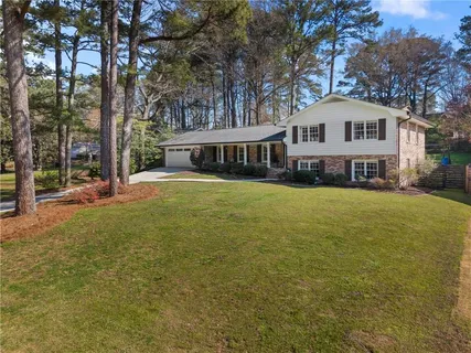 a front view of a house with a yard and trees