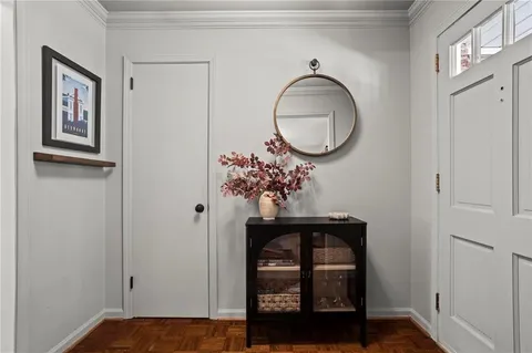 a view of a hallway with wooden floor and cabinet