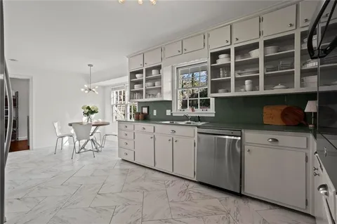 a kitchen with cabinets and chairs