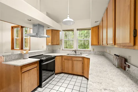 a kitchen with granite countertop sink stove and cabinets