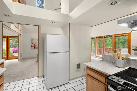 a kitchen with a refrigerator a stove top oven a sink and a window