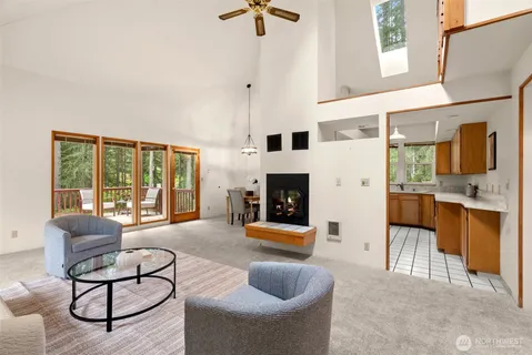 a living room with furniture a fireplace and a chandelier