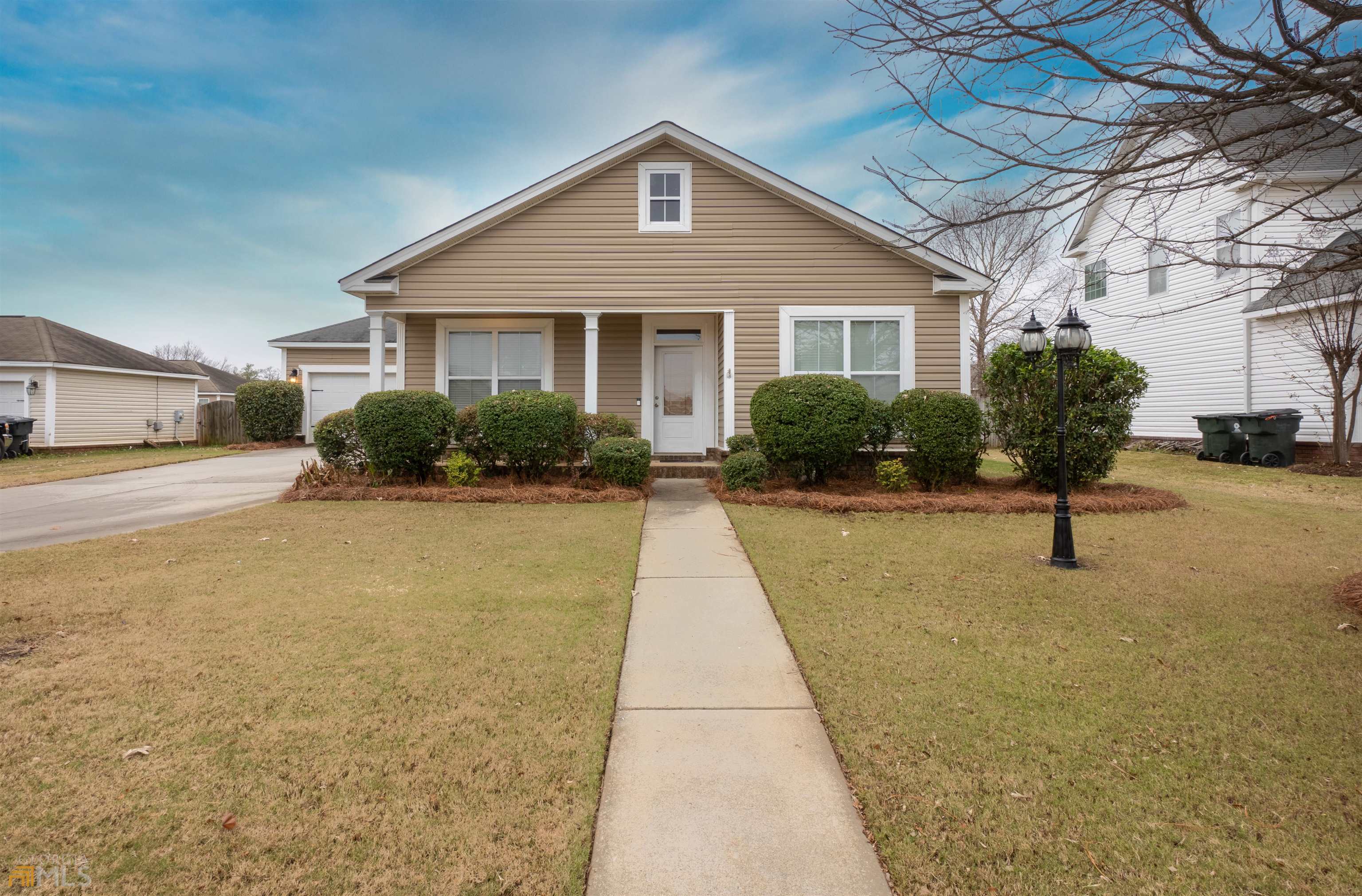 a front view of a house with a yard and potted plants