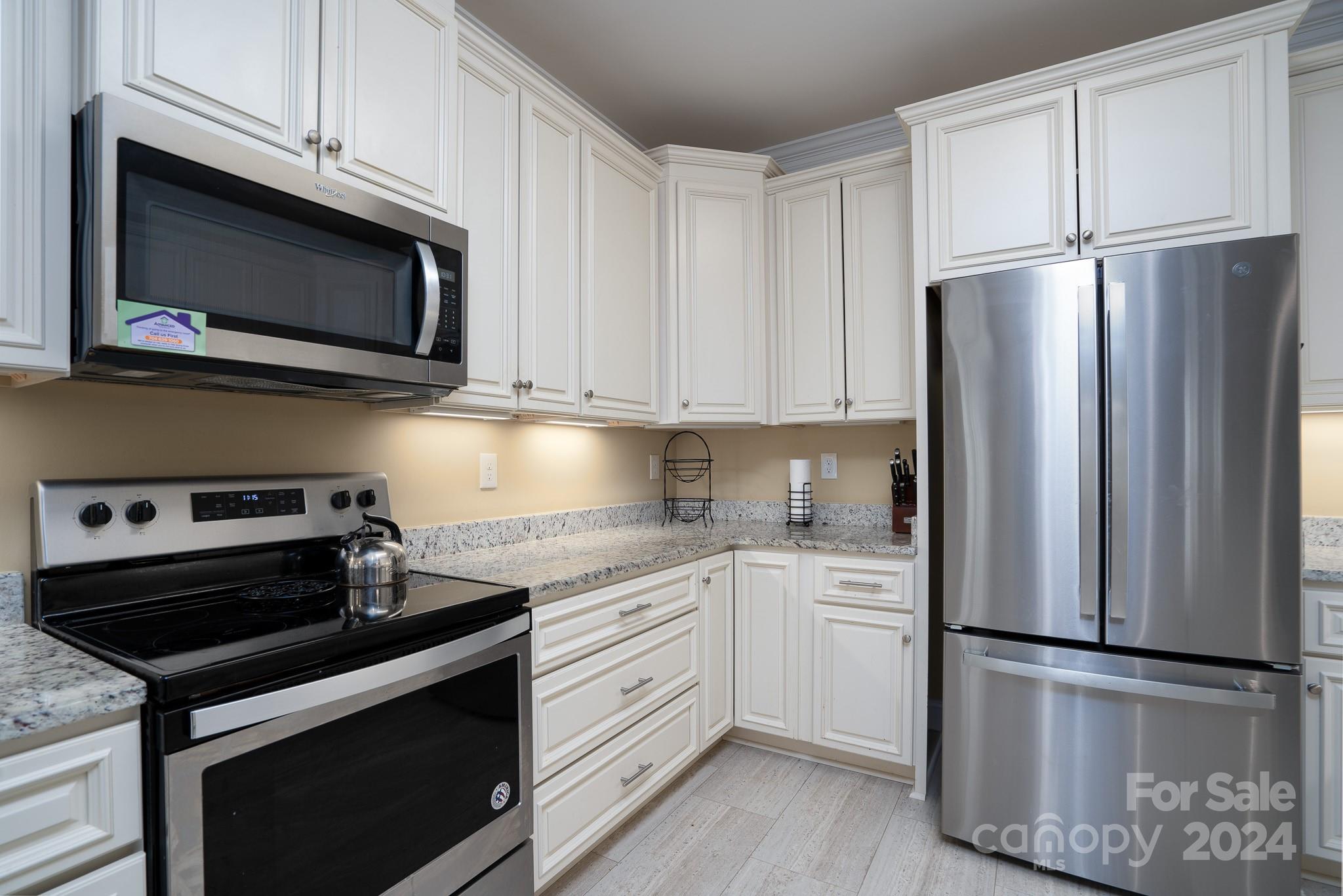 483 Pepperstone Drive Salisbury, NC 28146 - Photo 21 of 35 a kitchen with stainless steel appliances white cabinets white stove a microwave and a refrigerator