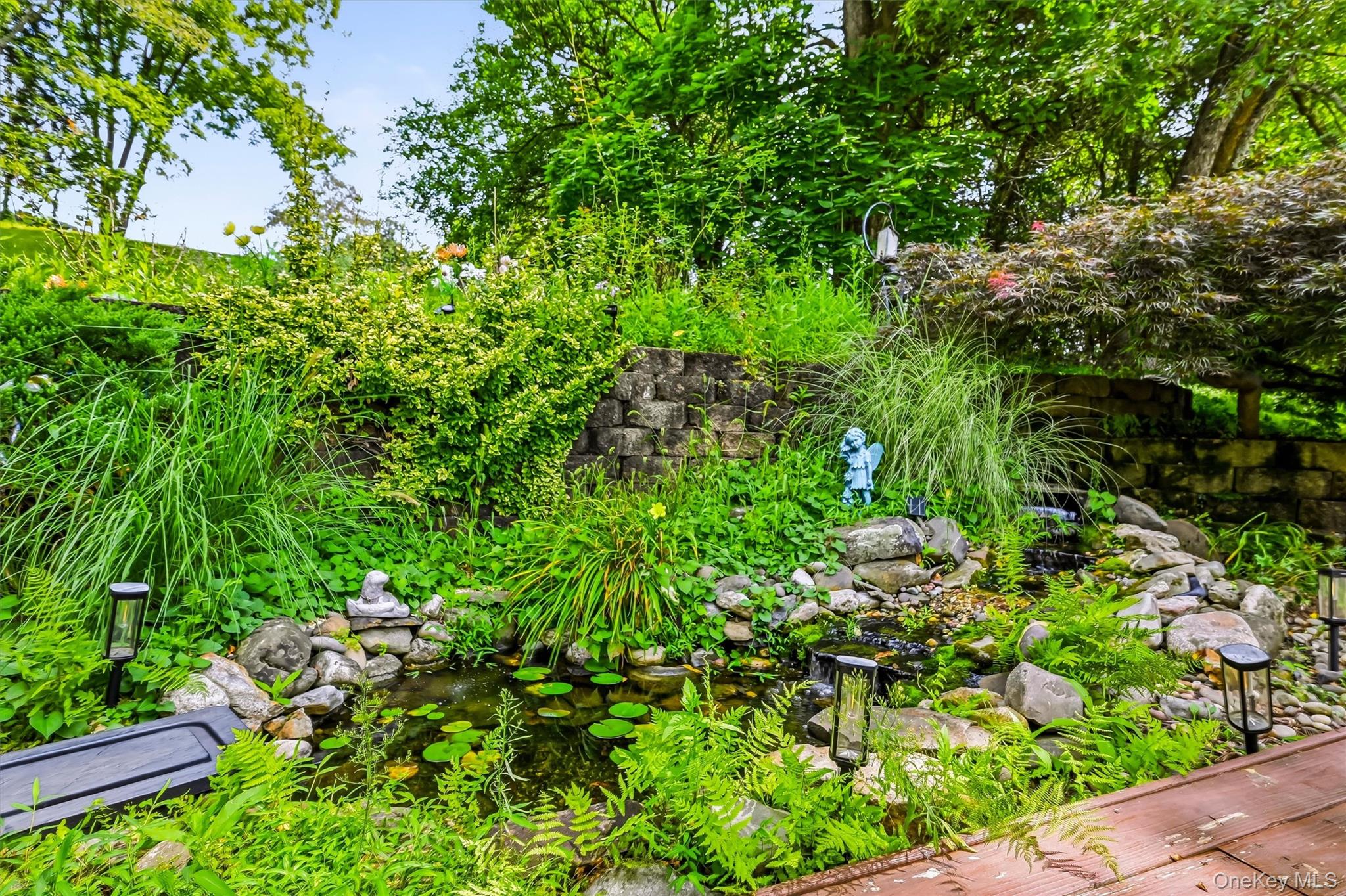 328 Big Island Road Florida, NY 10921 - Photo 30 of 40 Landscaped backyard pond with a waterfall and surrounding gardens.