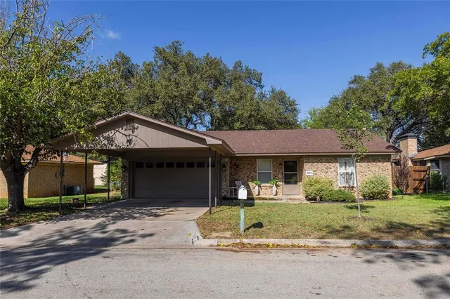 a front view of a house with a yard and potted plants