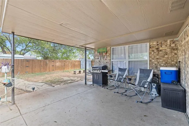 a view of a patio with table and chairs with wooden floor and fence