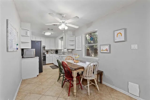 a view of a dining room with furniture and a chandelier fan