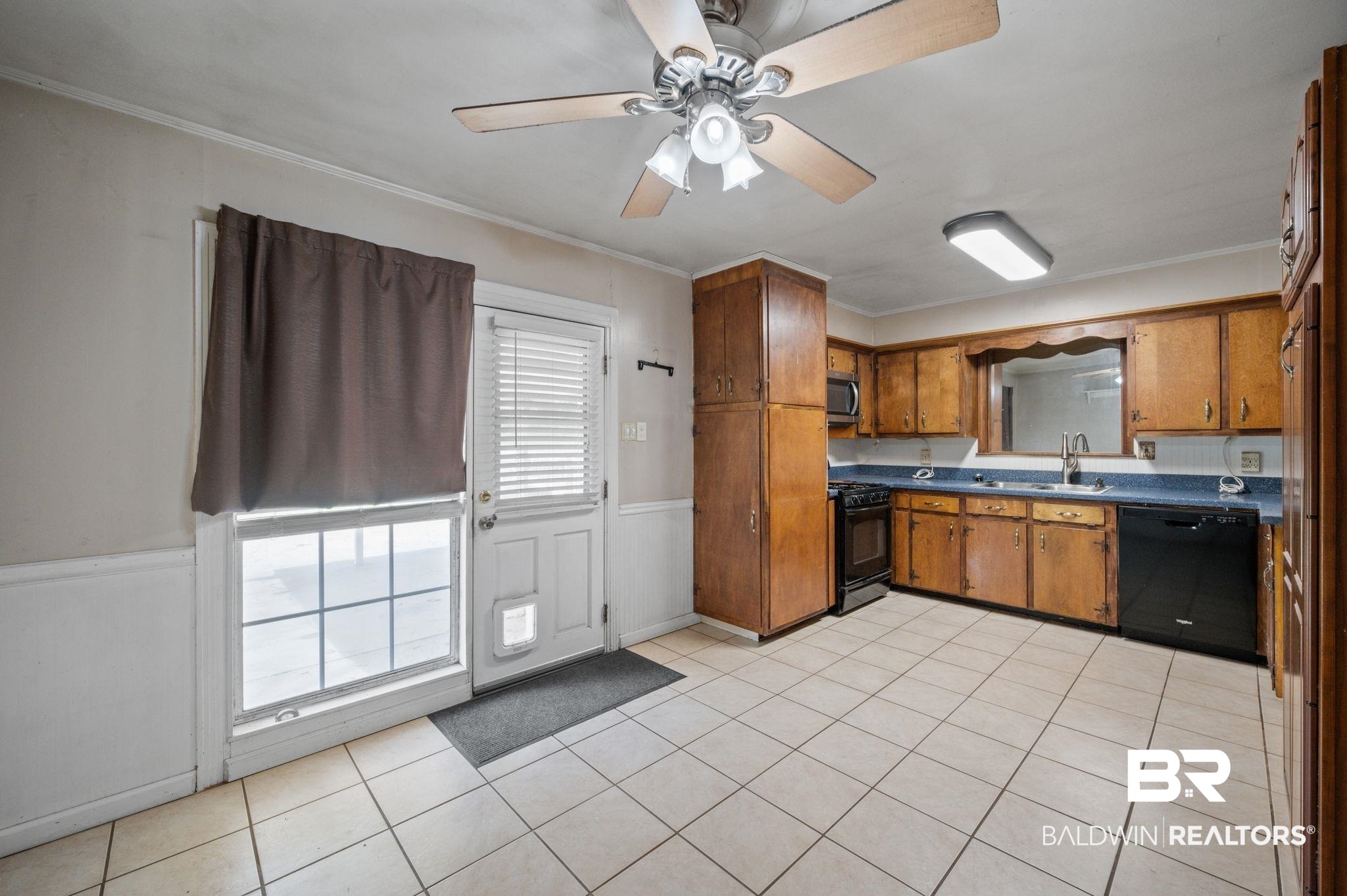 122 Rita Avenue Spanish Fort, AL 36527 - Photo 5 of 17 Kitchen with black appliances, ornamental molding, brown cabinets, and a sink