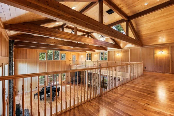 a living room with stainless steel appliances furniture a large window and a wooden floor