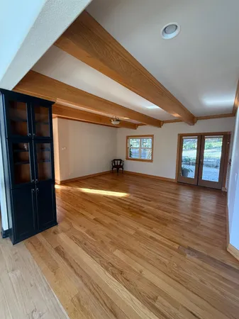 a kitchen with stainless steel appliances granite countertop a kitchen island a stove a sink a refrigerator dining table and chairs with wooden floor