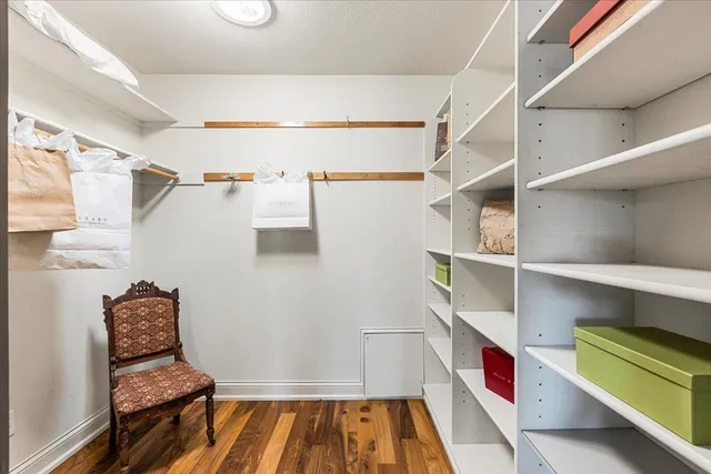 a view of walk in closet with clothes and shoes
