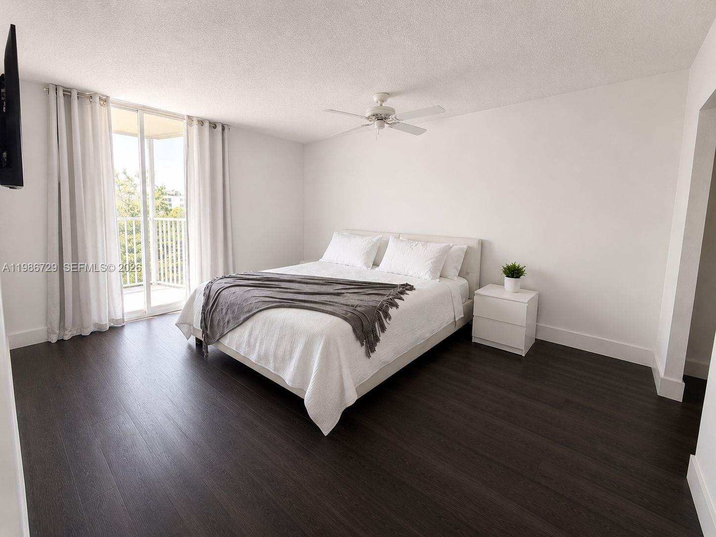 299 Northwest 52nd Terrace, Unit PHX Boca Raton, FL 33487 - Photo 1 of 16 a bedroom with a bed and a large window