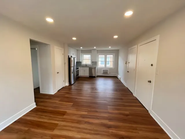 a view of an empty room with wooden floor
