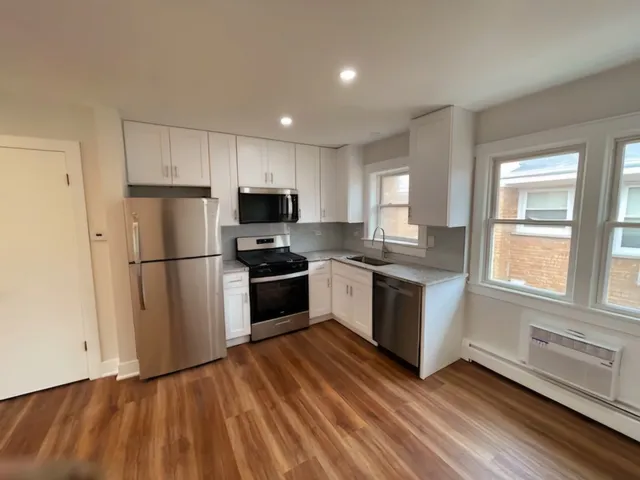 a kitchen with granite countertop stainless steel appliances a refrigerator sink and microwave