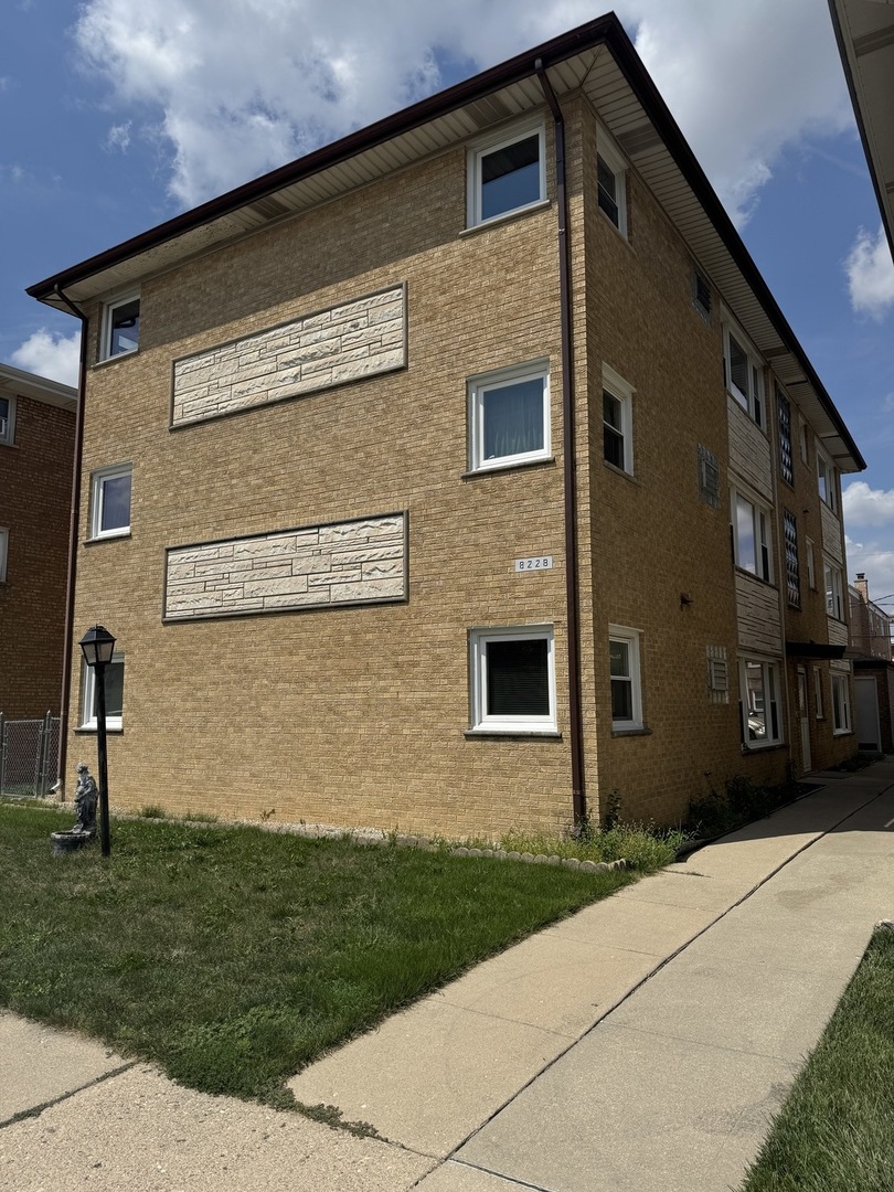 8228 West Walsh Lane, Unit 3F River Grove, IL 60171 - Photo 2 of 20 a front view of a house with a yard