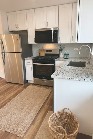 a kitchen with stainless steel appliances granite countertop a refrigerator sink and stove