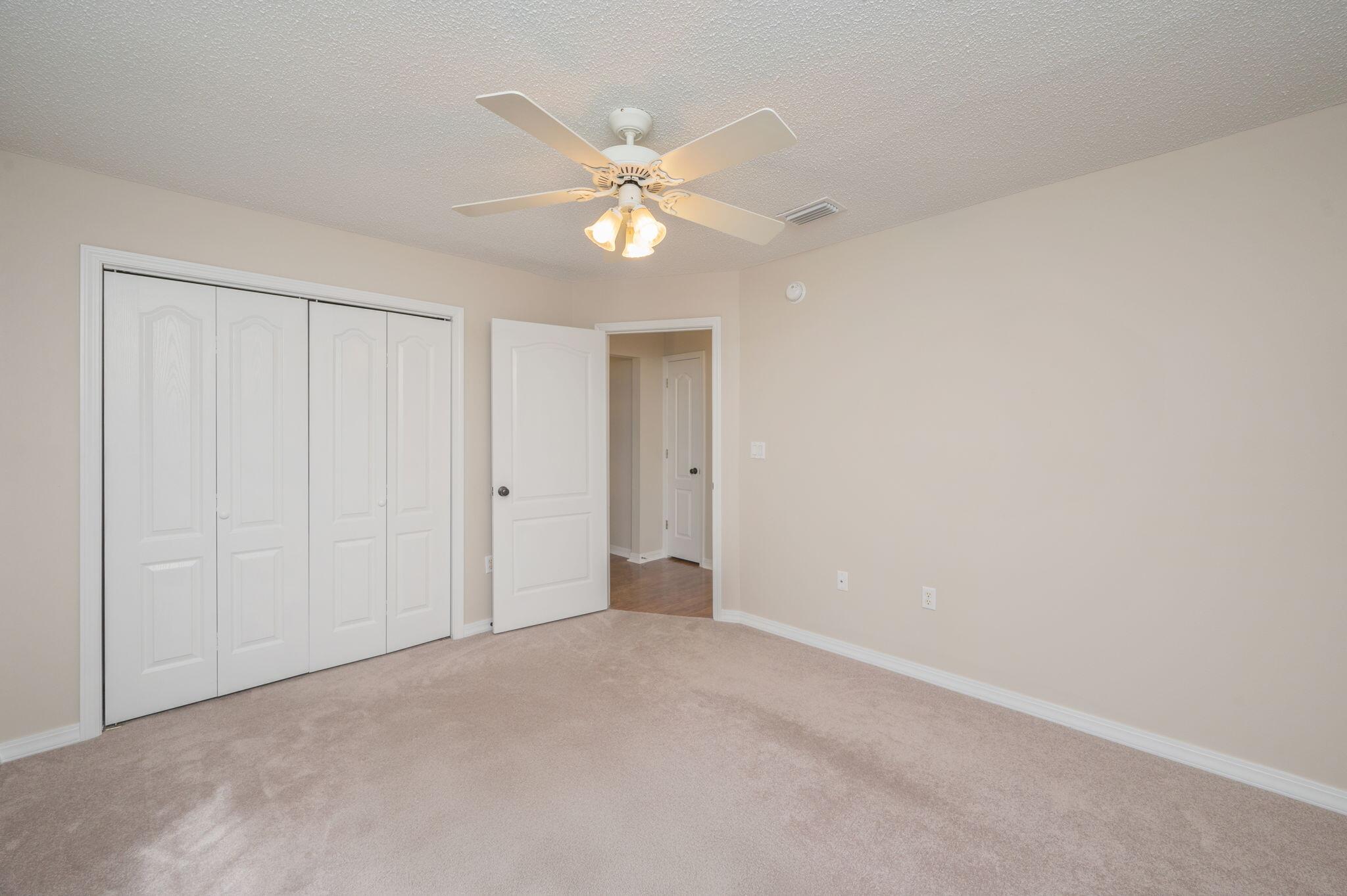 109 Eagle Drive Crestview, FL 32536 - Photo 33 of 52 a view of an empty room with window and chandelier fan