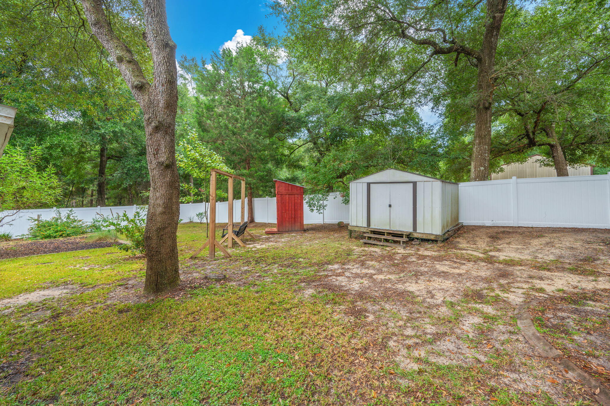 109 Eagle Drive Crestview, FL 32536 - Photo 50 of 52 a backyard of a house with a yard and large tree