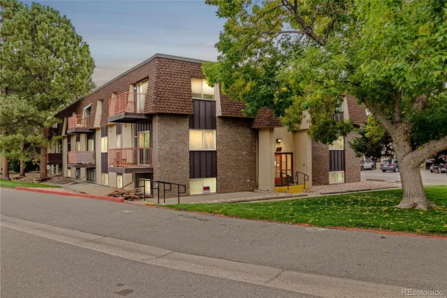 a front view of a house with a garden and tree
